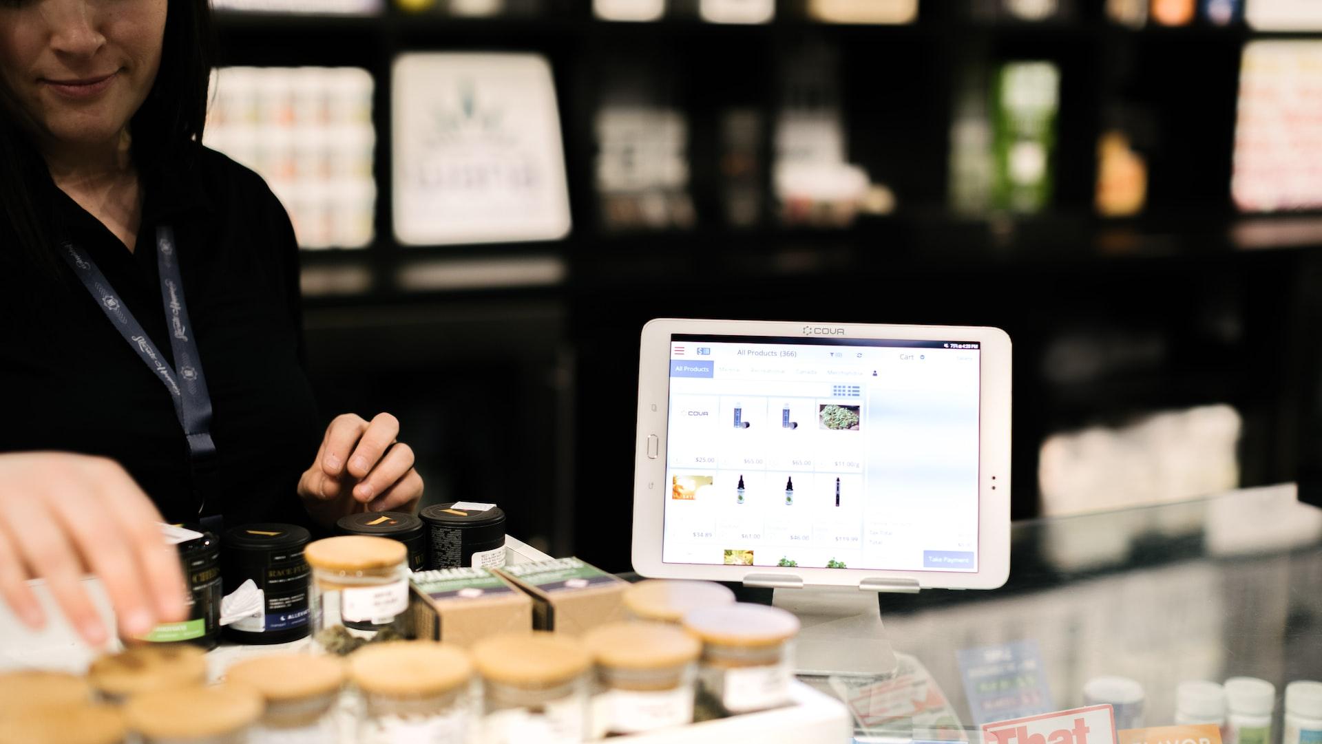 a woman standing behind a counter with a tablet